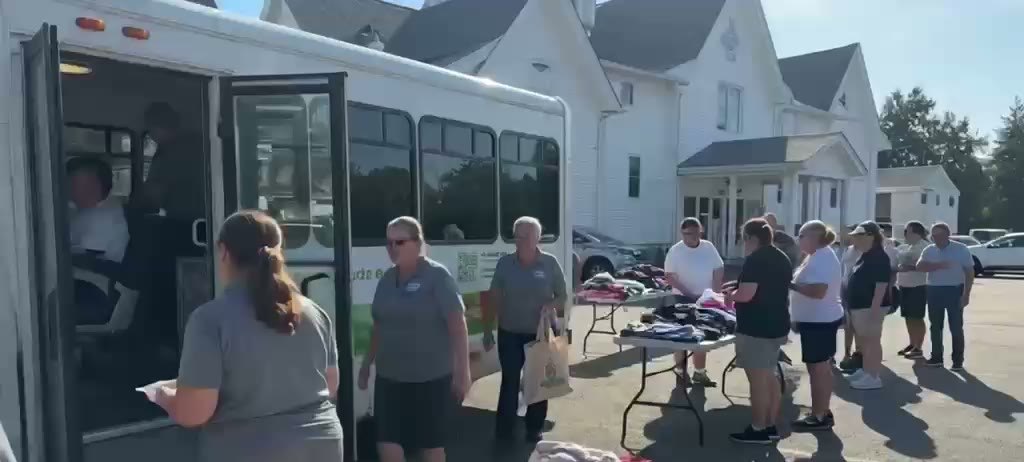 A clothing and food distribution day at tables beside a mobile unit